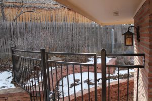 Metal fence and gate, curved, double open top three rail. Stepped from four feet to six feet to accommodate retaining wall.
